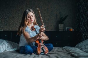 دختری ویولننواز که به نظر میرسد در ناحیهی دست احساس درد میکند