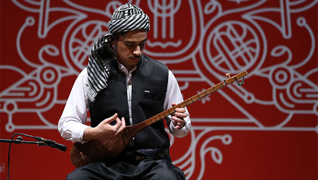 شخصی در حال نواختن تنبور در یک جشنواره موسیقی